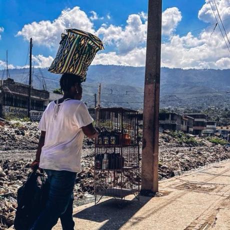 A woman fleeing her neighborhood due to violence. Port-au-Prince, Haiti